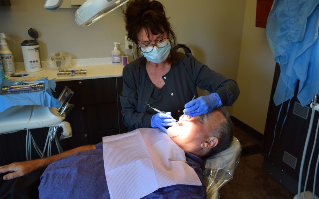 knoxville hygienist cleaning a man's teeth during a routine oral health appointment