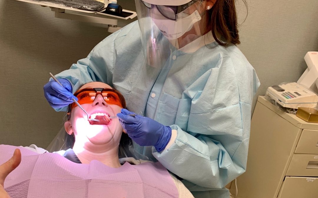 Knoxville dentists university general dentists team member working on a patient while practicing all covid guidelines, etc